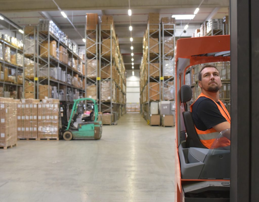 warehouse worker in a forwarding agency - interior with forklift - transport and storage of goods