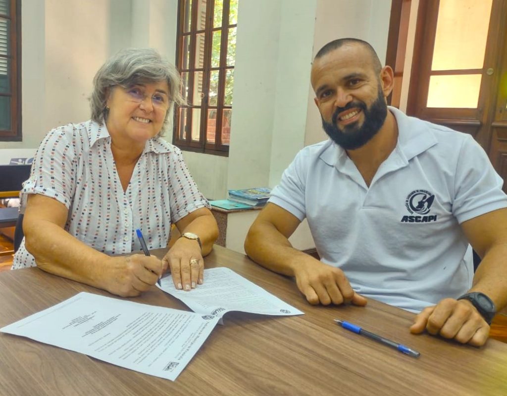 Assinatura do termo entre a secretária Branca e Thiago Ganeoo, representante da Ascapi