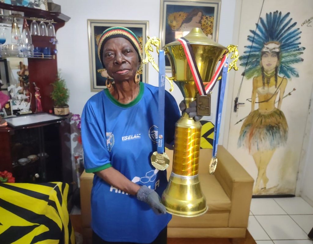 Dona Odete Martins Teixeira, conhecida como Mama África, em sua residência, orgulhosa com um dos Troféus conquistados em 2023