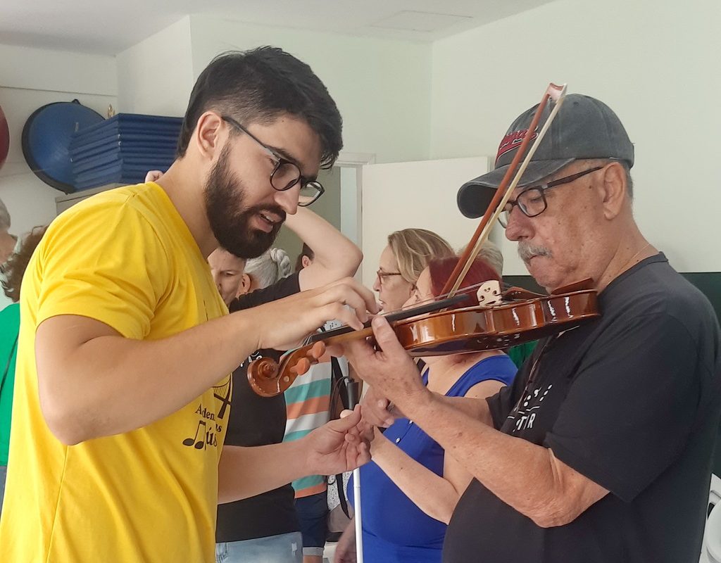 O professor Felipe Porsebon com participante em ação inclusiva da 
Academia Jovens Músicos (Foto: Eliane Deliberali)