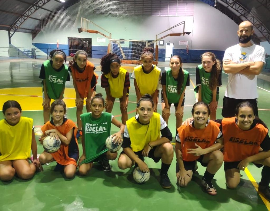 O professor Rodrigo Dias e as alunas da turma de futsal feminino