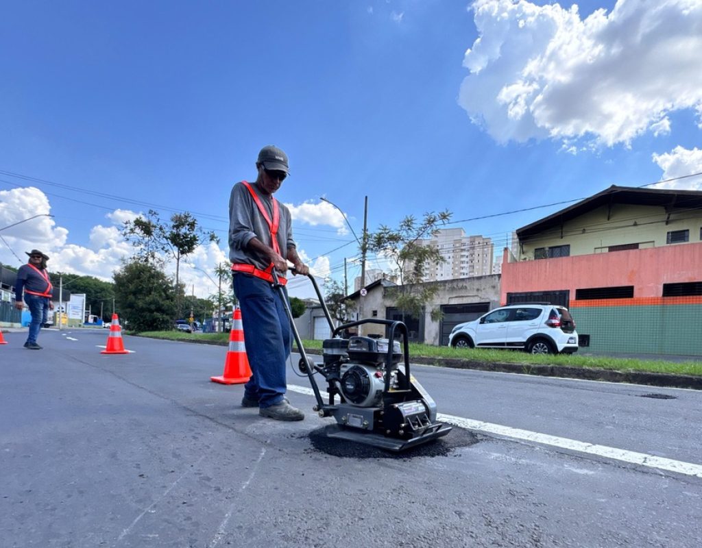 Para facilitar a cobertura de aberturas de pequeno diâmetro no asfalto, equipe utiliza placa vibratória e massa fria. (Foto: Divulgação)