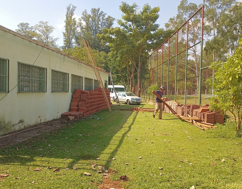 Trabalhador carregando madeira na reforma do Cras São José