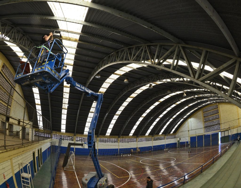 Trabalhador executa a troca do sistema de iluminação do Ginasio de Santa Terezinha