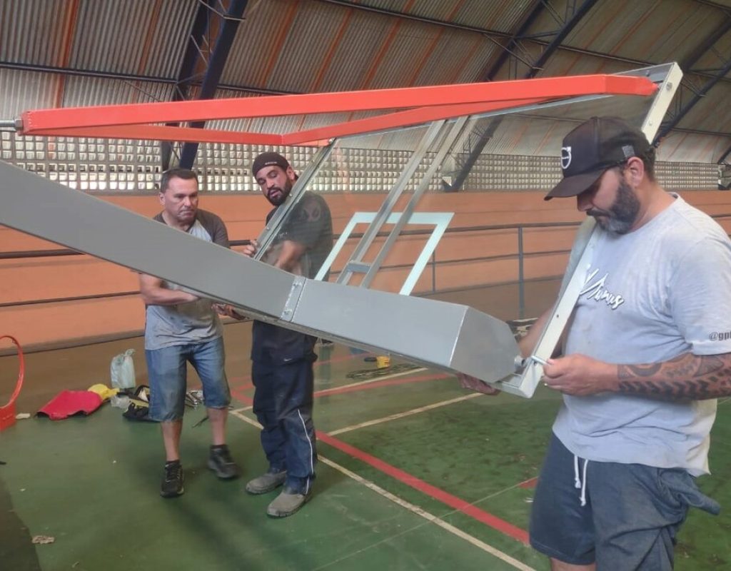 Trabalhadores instalam a estrutura de basquete no Ginásio da Vila Sônia