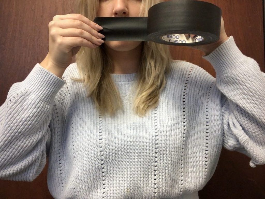 a-woman-with-duct-tape-on-her-mouth-silence