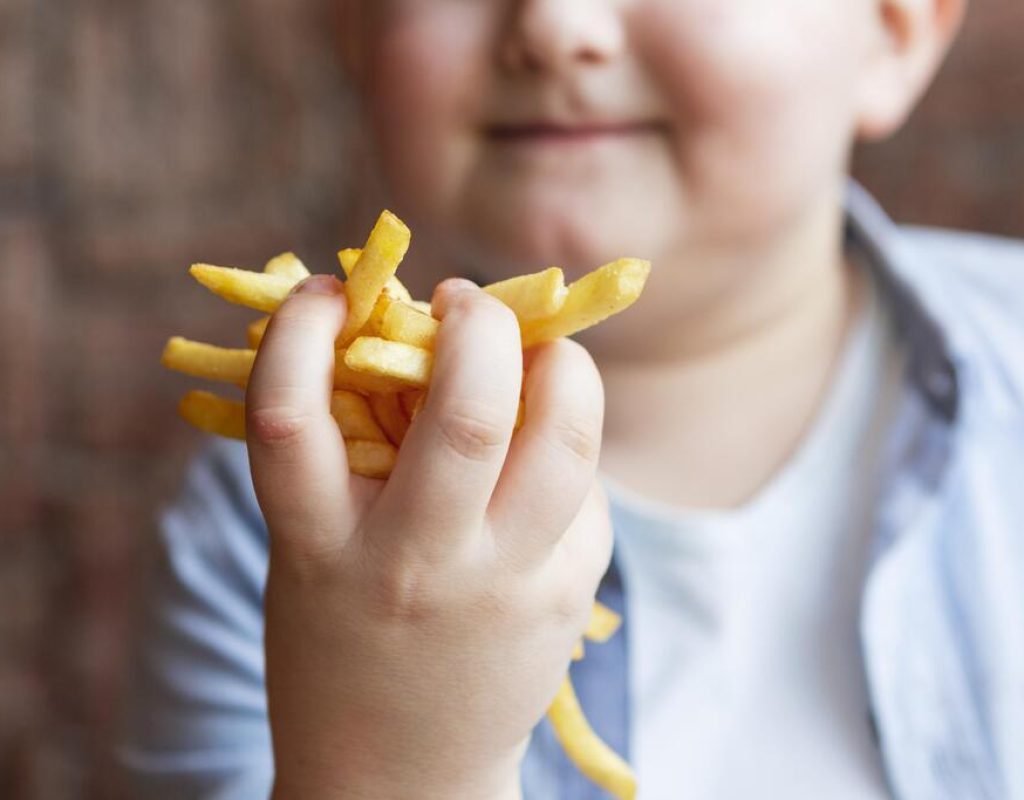 feche-garoto-segurando-batatas-fritas (1)