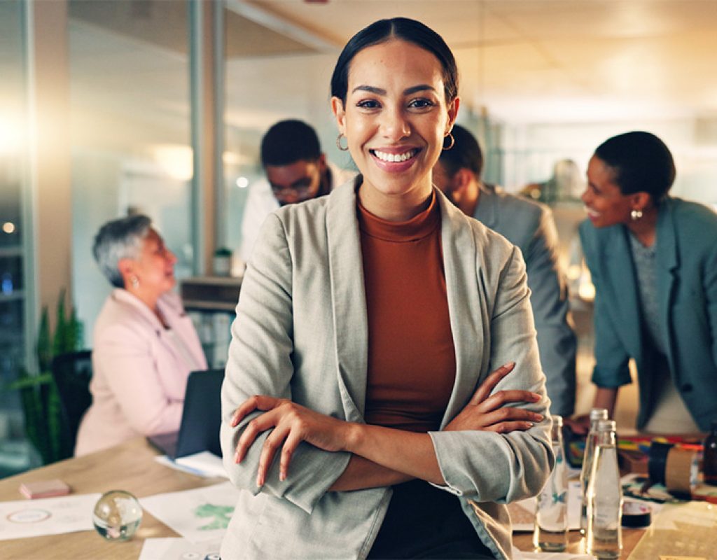 Face, business and woman with arms crossed, smile and career with teamwork, meeting or planning. Portrait, person or employee with cooperation, staff or professional with brainstorming in a workplace